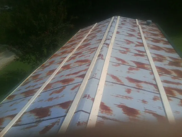 Rusted metal roof panels with new wood purlins before replacement — Storm Damage Roof Repair in Earlville by Roofing Brothers